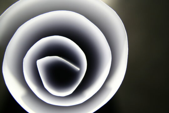 Papel blanco para impresoras arrollado en c&igrave;rculos con luz superficial presenta un dise&ntilde;o fractal con luces y sombras de bordes suaves, formando un bello dise&ntilde;o abstracto con fondo negro