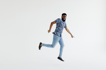 I did it. Full length of handsome young black man jumping against white background