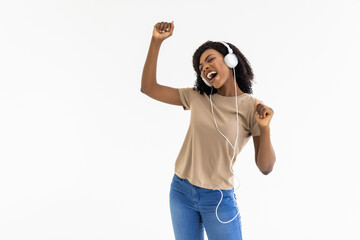 Happy woman dancing to the music with headphones isolated over white background