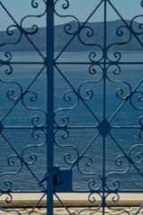 Part of a traditional metallic door and view of the aegean sea in Santorini