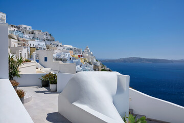 Breathtaking view of a rooftop, the picturesque village of Fira and the aegean sea on a sunny day...