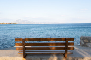 Naklejka na ściany i meble Empty wooden bench by sea. No people.