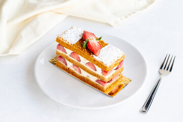 Strawberry cake slice on a white background. Layered cake with cream and strawberry. close up