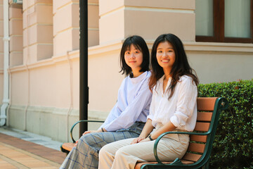 young college female girl student sit on bench and chat old university campus