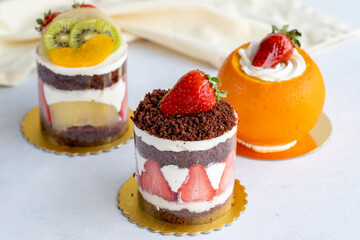 Assorted mini cakes with fruit on a white background. close up