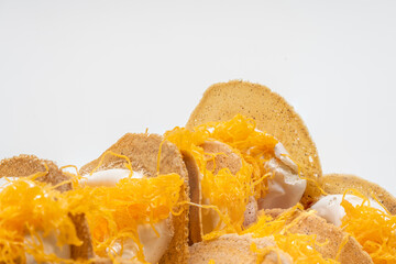 Close up crispy pancakes with white soft cream and golden egg yolk boiled in syrup taste is sweet,White background.