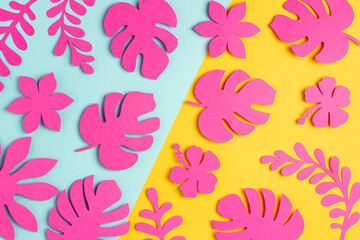 Fototapeta na wymiar Trendy sunlight tropical pattern made with bright pink paper flowers and leaves on blue yellow background, as backdrop or texture. Minimal floral concept. Wallpaper for your design. Paper art