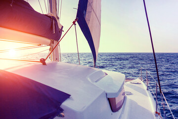 Yachting as a luxury sport and great vacation. Sailing catamaran at sunset in the sunin the sea...