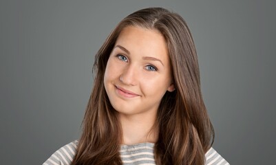 Naklejka premium Beautiful face of young woman on grey wall. Successful happy woman.