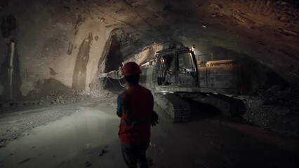 Dnipro, Ukraine - August 27, 2021: Construction Worker Controls Heavy Equipment During Tunnel Construction. Excavator with Hydro Hammer Breaks Stones