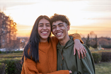 portrait of latin teenage couple smiling at sunset