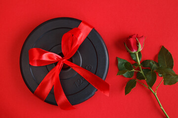 Ribbon wrapped dumbbells barbell weight plate and rose as a love gift for Valentine's Day,...