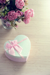 heart gift box with rose flowers bouquet on table, abstract blurred background. spring summer season, festive composition. romantic gift for women. top view. copy space