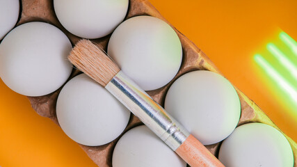 Paint brush with eggs on abstract yellow and green background