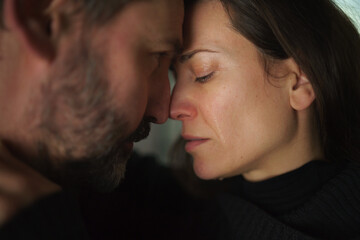 Close-up of woman crying when hugging her husband.