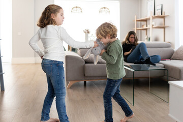 Sibling fighting over toy in living room