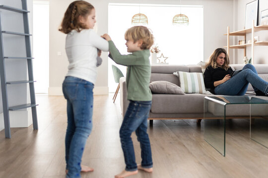Sibling fighting over toy in living room