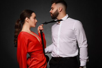 Handsome bearded man with sexy lady on dark background
