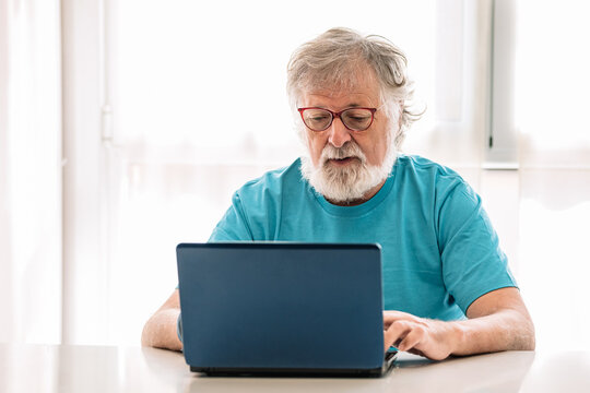 Elderly man with laptop at home