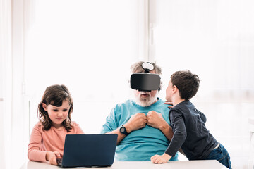 Scared grandfather in VR goggles near children