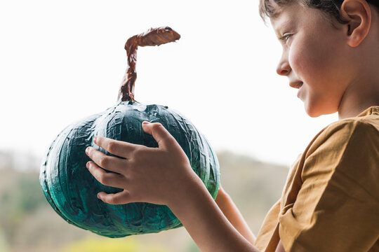 Smiling cute boy with teal pumpkin