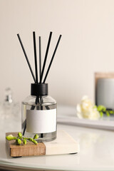 Aromatic reed air freshener on white table, space for text
