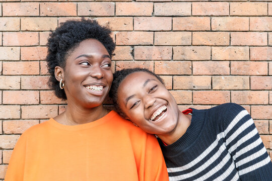 happy black women near brick wall