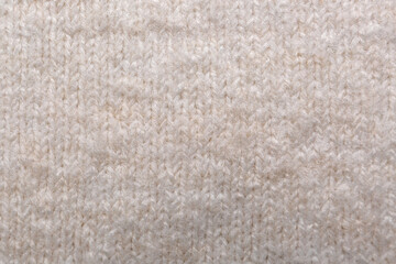 Soft beige knitted fabric as background, top view