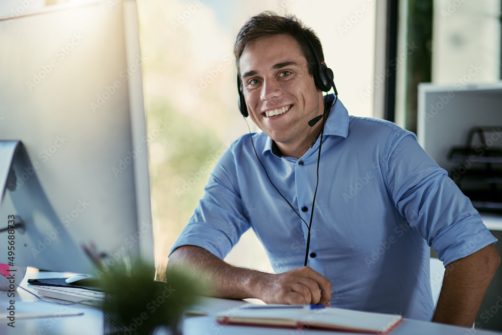 Poster hes standing by to take your call. portrait of a call centre agent working in an office.