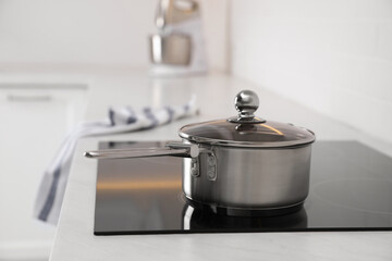 New clean saucepan on cooktop in kitchen - obrazy, fototapety, plakaty