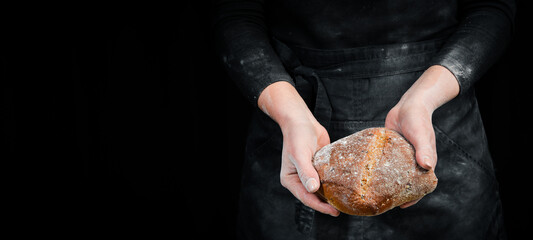 Fragrant ciabatta in women's hands, food photography recipe idea. Black baking background.