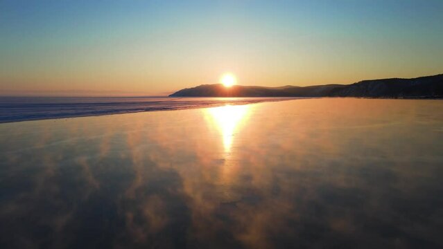Lake at sunset. Steam rises above the clean river. Sun is reflected in the water