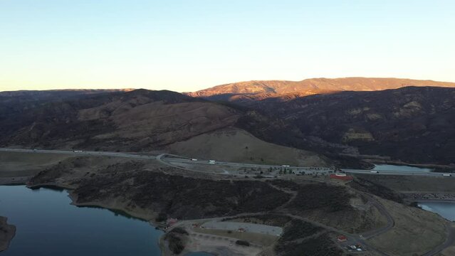 Cars travel on interstate 5 next to Pyramid Lake on the Tejon Pass. Vaquero Beach and Visitor Center.