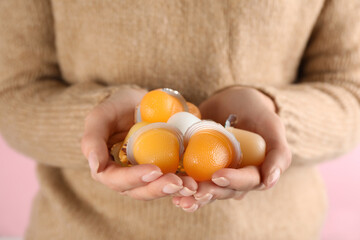 Woman holding many tasty bright jelly cups on pink background, closeup