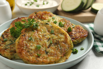 Delicious zucchini fritters served on table, closeup