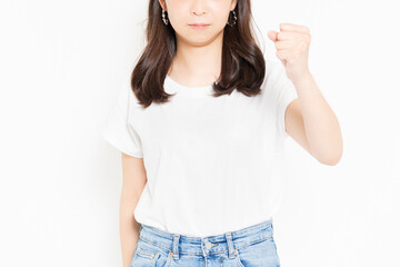 白背景の前で腕を振り上げて怒っているTシャツ姿の若い女性