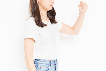 白背景の前で腕を振り上げて怒っているTシャツ姿の若い女性