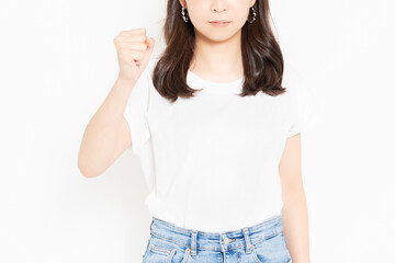 白背景の前で腕を振り上げて怒っているTシャツ姿の若い女性