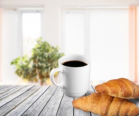 Espresso or black coffee in white cup with croissants