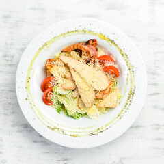 Salad with chicken and bacon. Top view. On a dark background. Cold snacks.