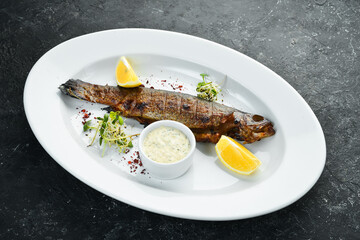 Grilled trout with vegetables on a plate. Seafood on the menu. Top view.