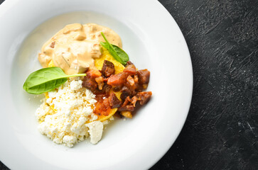 Banosh with mushrooms, bacon and brynza cheese on a plate. Hungarian traditional cuisine. Top view.