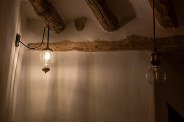 Lámpara tipo farolillo antiguo encendido con iluminación tenue en casa rústica, bombilla apagada