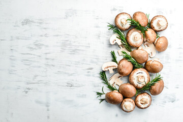 Fresh champignon mushrooms on a white wooden background. Organic food. Rustic style. Top view.
