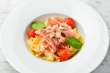 Pasta with prosciutto, blue cheese and tomatoes. Italian cuisine. Menu. Top view.
