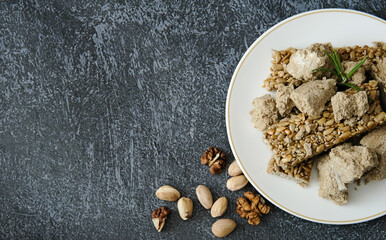 Oriental sweets on a light plate. Sunflower halva, sunflower gozinak. Copy space.