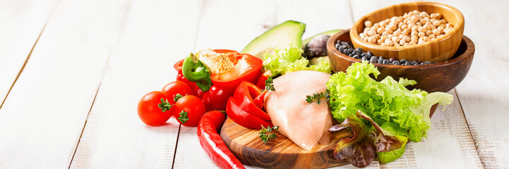 Raw chicken and fresh vegetables on a table. Healthy food. Selective focus. Copy space
