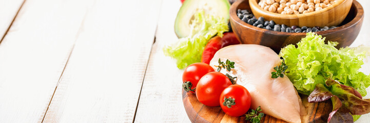Raw chicken and fresh vegetables on a table. Healthy food. Selective focus. Copy space