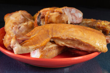 Smoked chicken meat on a red plate