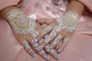 Beautiful Henna in the Hand of the Bride. mehendi young woman painting henna on hand. Detailed...